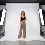 Pantalón beige de tiro alto con pinzas y pernera ancha; modelo con caída recta.