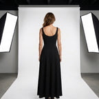 Vestido negro de espalda descubierta parcial, con tirantes y falda midi acampanada.