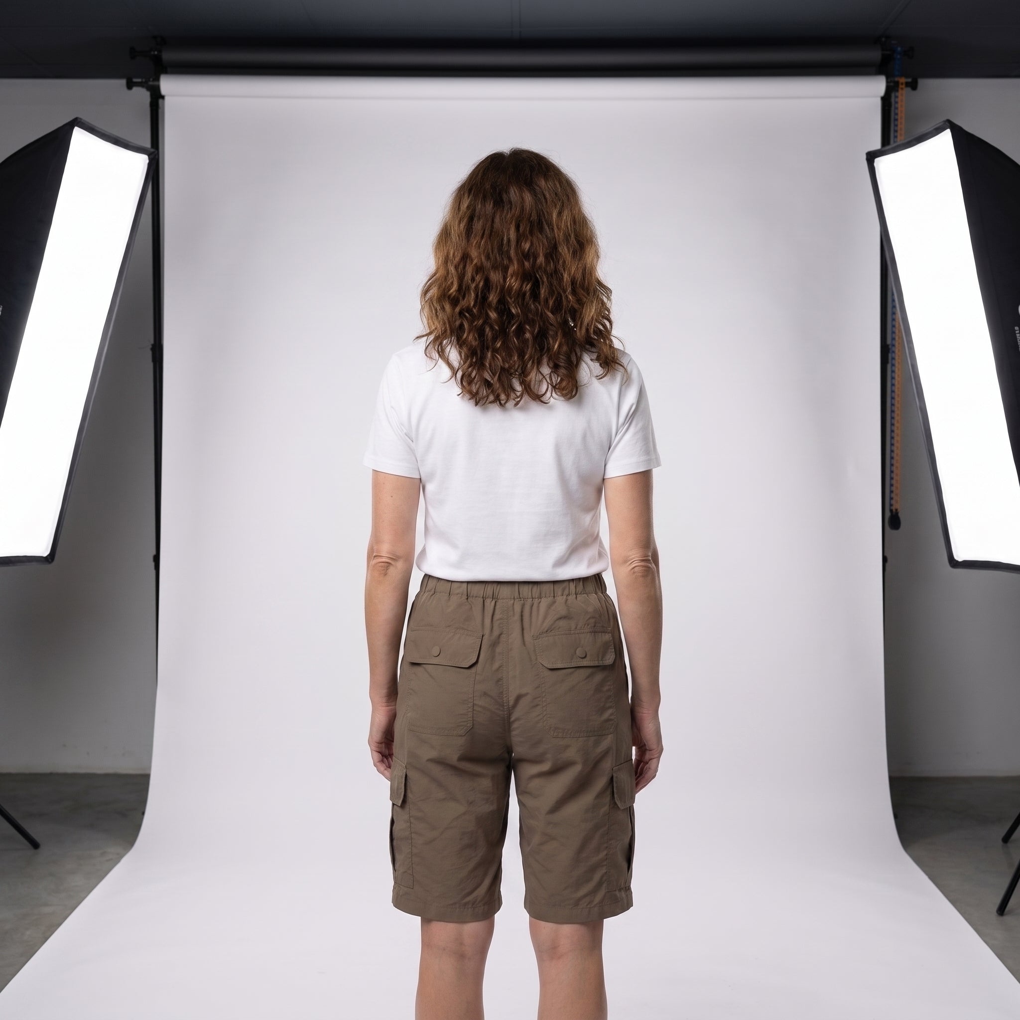 Short cargo marrón con cintura elástica y bolsillos utilitarios, vista trasera.