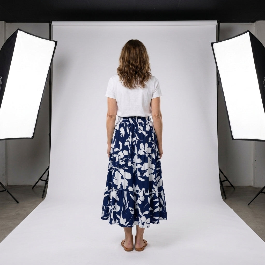 Falda plisada larga azul marino con flores blancas; vista trasera y cintura elástica