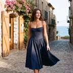 Vestido azul marino con tirantes finos, escote corazón y falda plisada con vuelo.