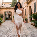 Vestido blanco de un hombro con manga larga y falda con flecos y abertura