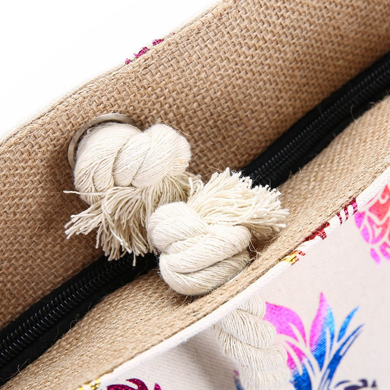 Detalle de nudo en las asas del bolso tote y cremallera negra en tela beige