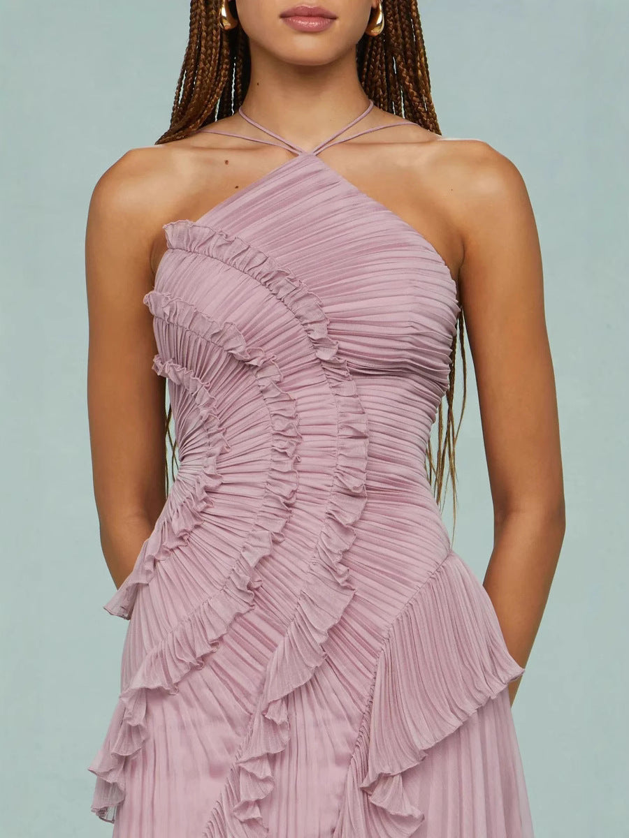 Detalle de vestido rosa con tirante cruzado halter y volantes fruncidos en el corpiño.