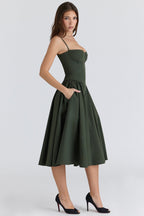 Vestido verde oscuro con tirantes finos, escote corazón y falda acampanada plisada.