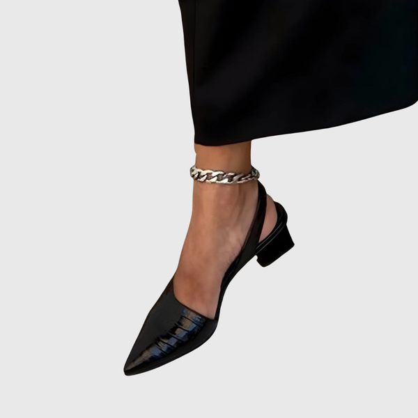 Merceditas Laia negras de charol con tacón bajo y pulsera de cadena en el tobillo.