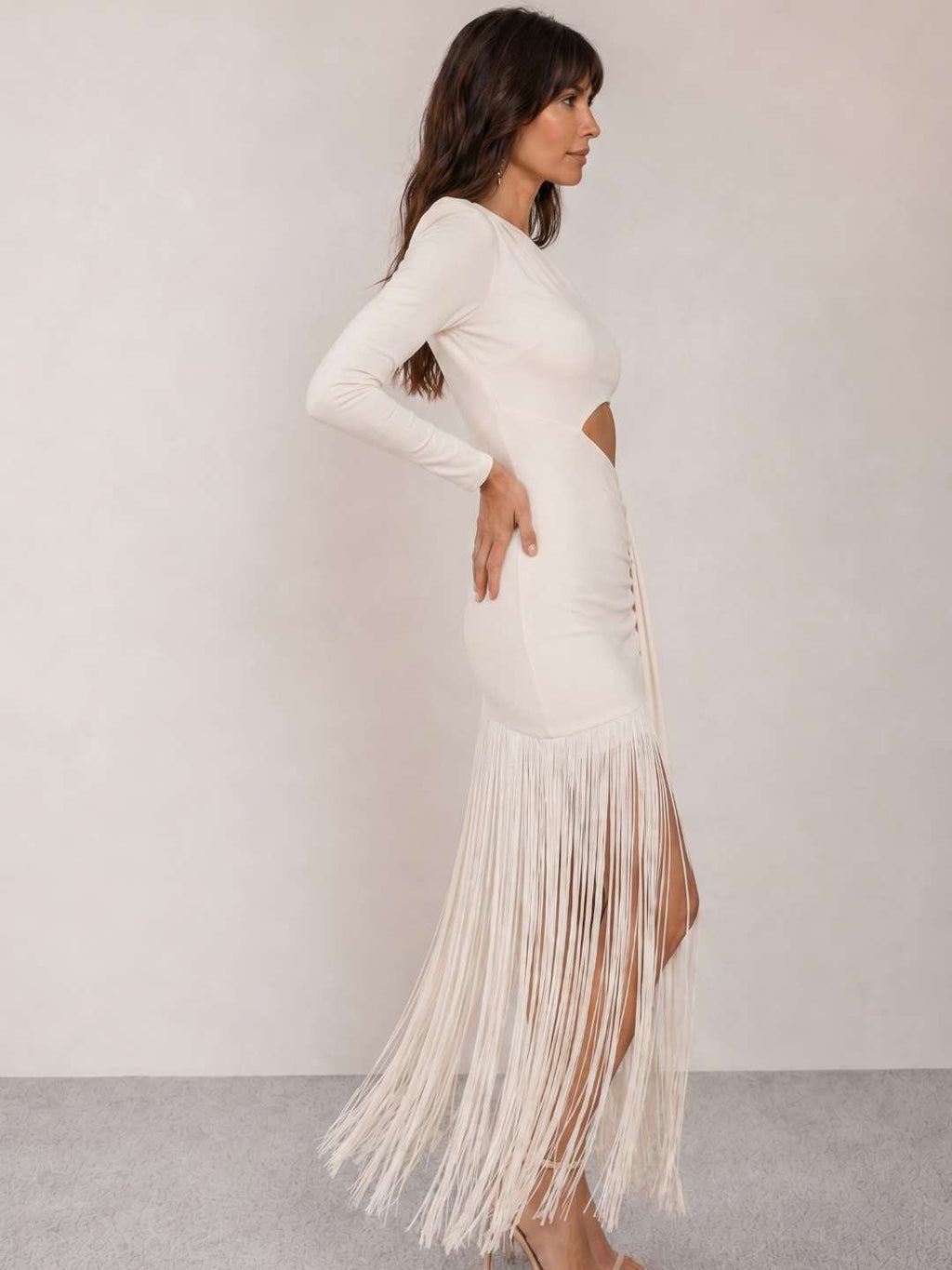 Vestido blanco asimétrico de un hombro con manga larga y falda con flecos