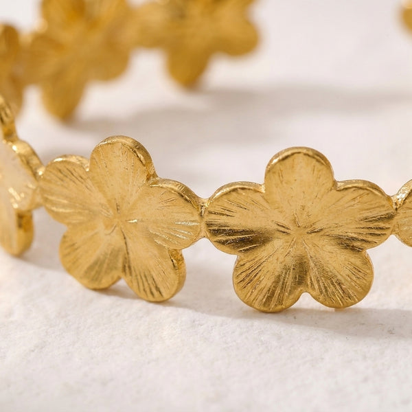 Brazalete dorado con flores de cuatro pétalos en eslabones