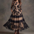 Vestido de tul con bordado floral negro y falda en capas; manga francesa semitransparente.