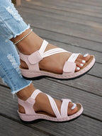 Sandalias rosa palo con tiras dobles y hebillas, punta abierta, suela plana de perfil bajo.