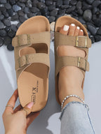 Sandalias beige de cuero con dos correas y hebillas metálicas, plantilla interior visible