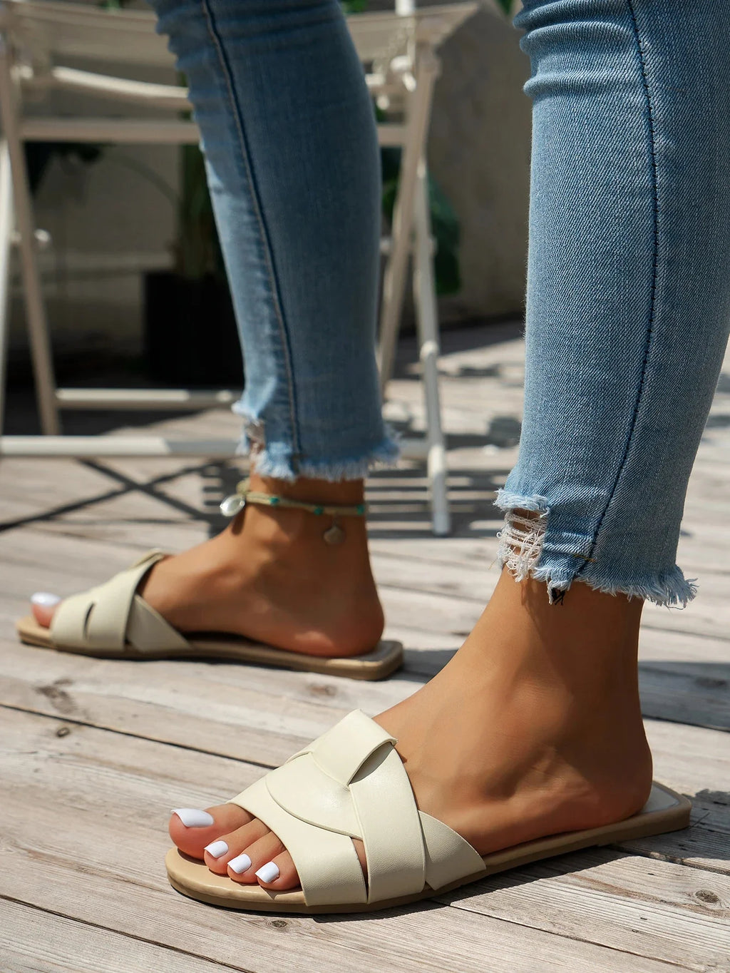 Sandalias de tiras beige con suela plana y detalle cruzado en el empeine