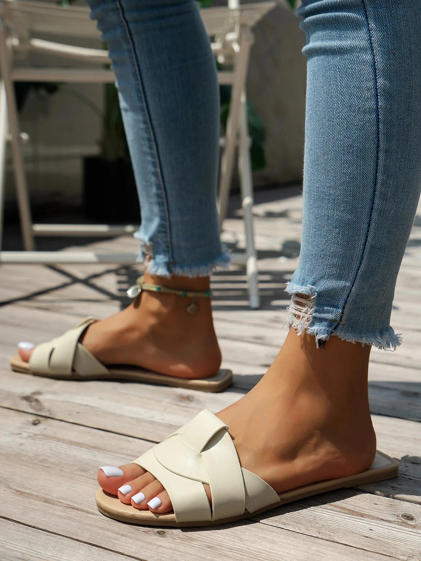 Sandalias de tiras beige con suela plana y detalle cruzado en el empeine