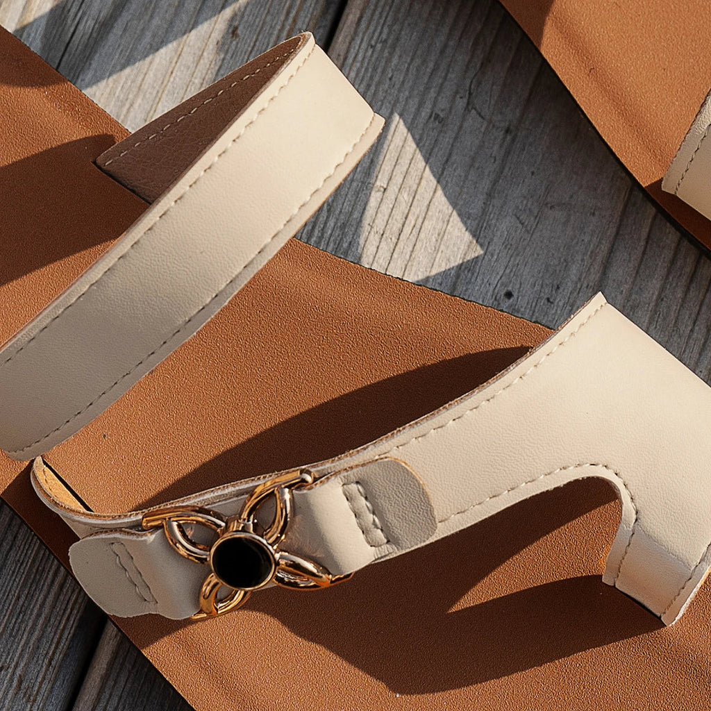 Chanclas de tiras beige con hebilla metálica y suela oscura