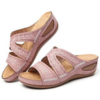 Sandalias rosas con tiras caladas y flores, detalle de talón y costuras blancas