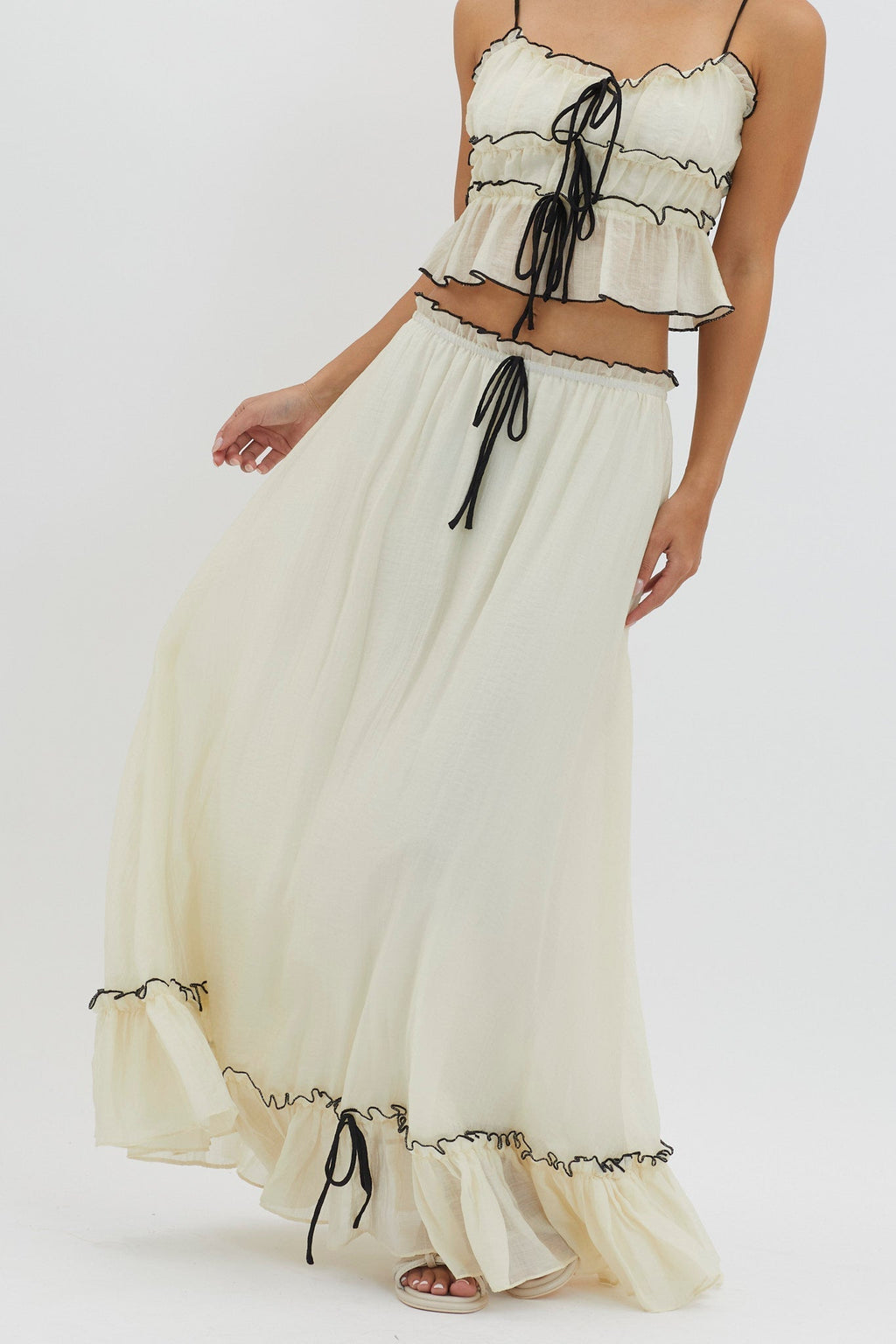Conjunto marfil: top con volantes y cordones negros y falda larga con lazos
