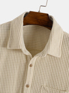 Camisa beige texturizada con cuello camisero y botones marrones