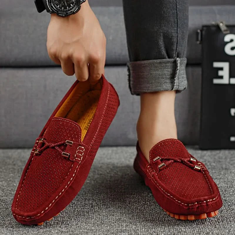 Mocasines de cuero perforado color rojo con hebilla metálica y suela de tachones