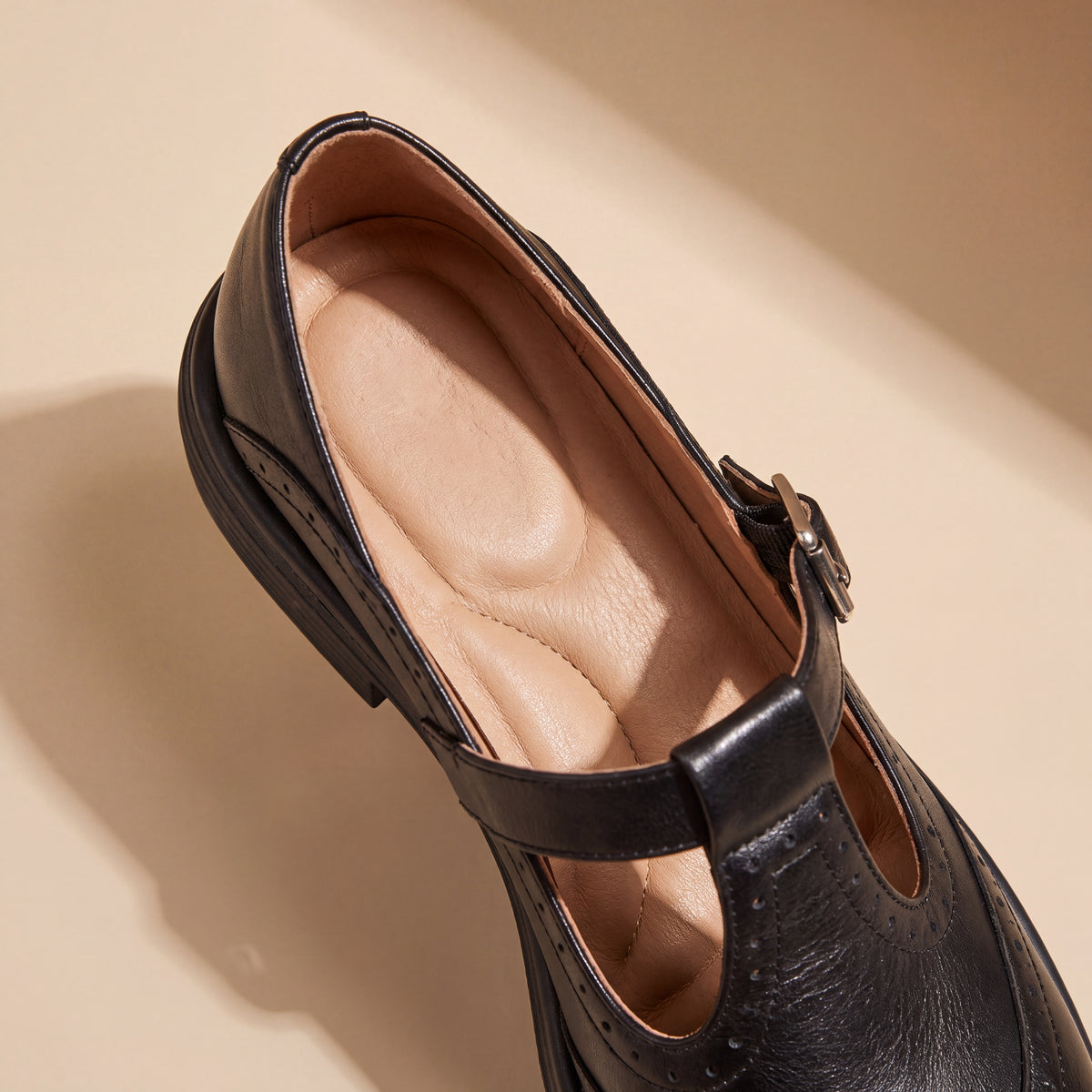 Mocasín Louisa™ de cuero negro con hebilla y perforaciones, vista lateral