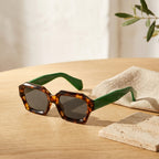 Gafas Ventura Terra con montura carey y patillas verdes, lentes oscuras