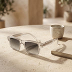 Gafas con montura transparente y lentes grises oscuras, armazón rectangular