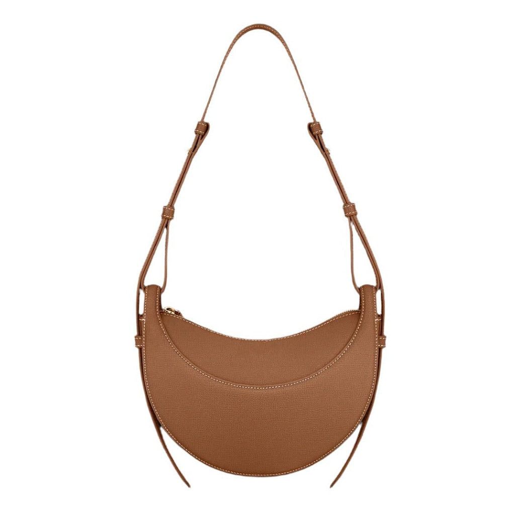 Bolso hobo de cuero color caramelo, asas de hombro y panel curvo frontal.