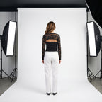Top negro de encaje floral con panel liso y manga larga transparente, escote tipo barco
