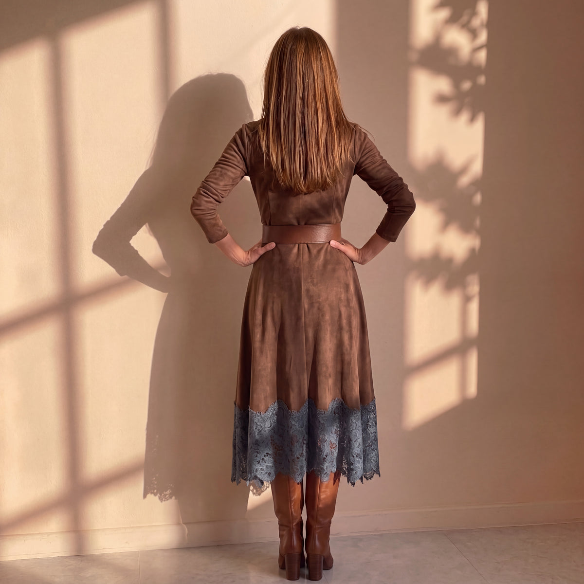 Vestido marrón oscuro de cuello alto con cinturón y bajo con encaje azul, trasera.