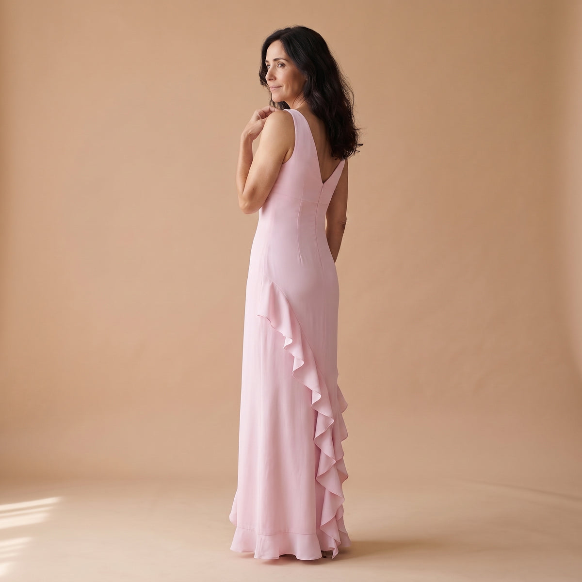 Vestido largo sin mangas rosa, escote en V y volantes asimétricos en el bajo