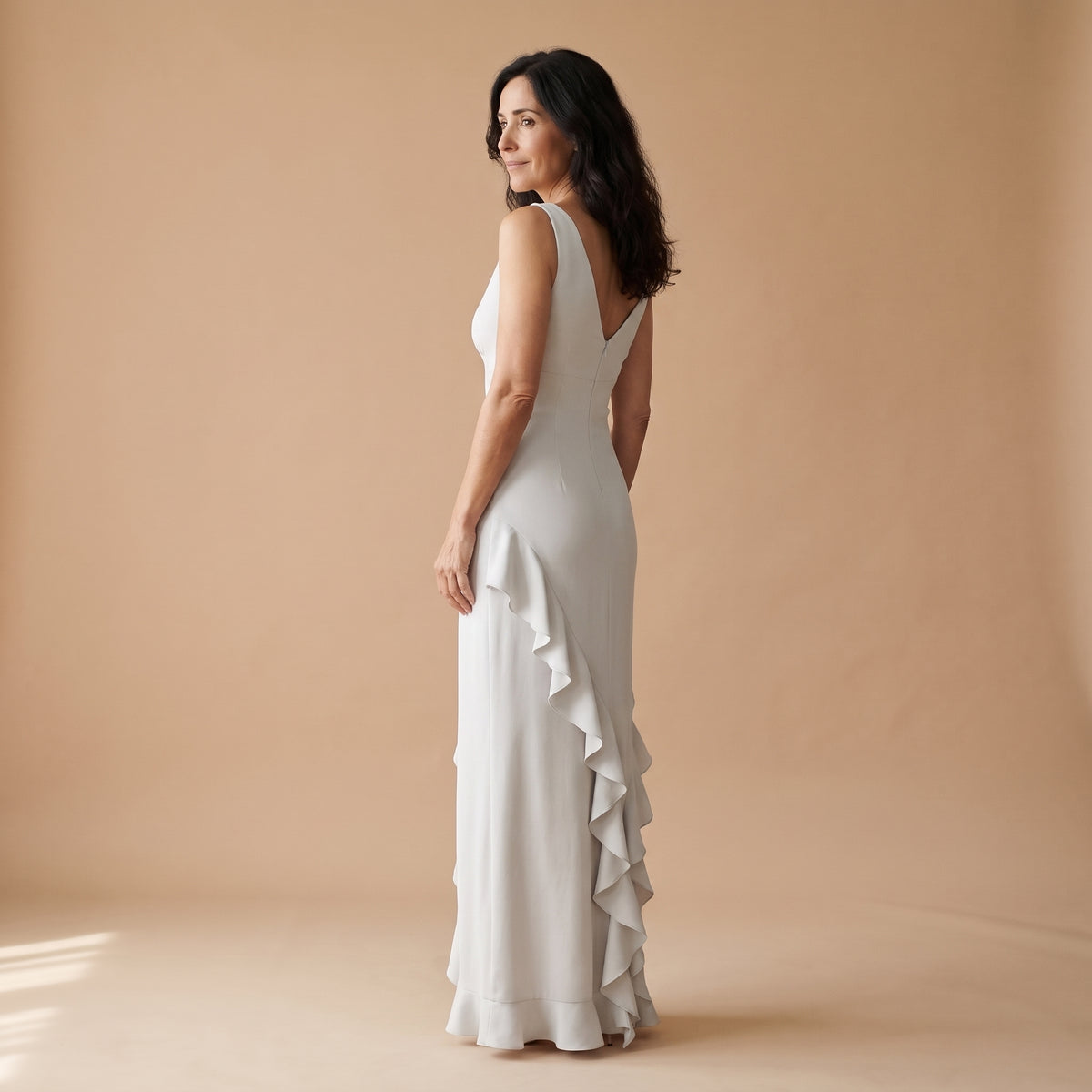 Vestido largo blanco sin mangas con escote en V y volantes asimétricos en la falda