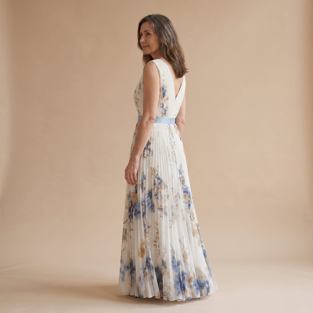 Vestido largo sin mangas, escote V cruzado y falda plisada con estampado azul sobre fondo claro