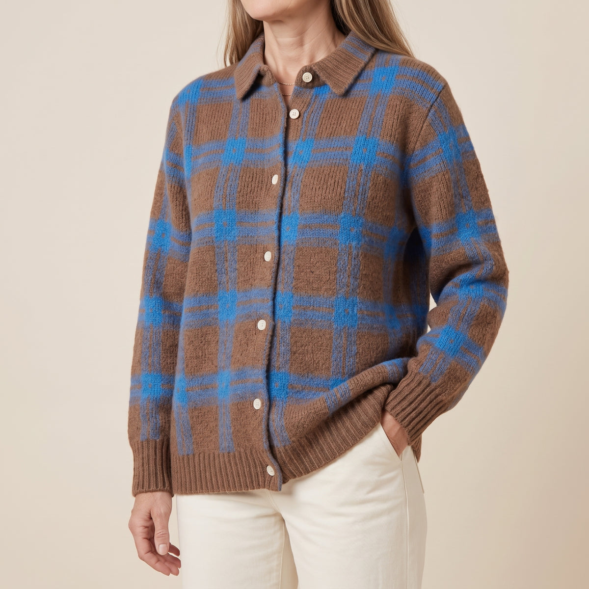 Suéter de punto azul y café con cuadros, cuello tipo camisa con botones.