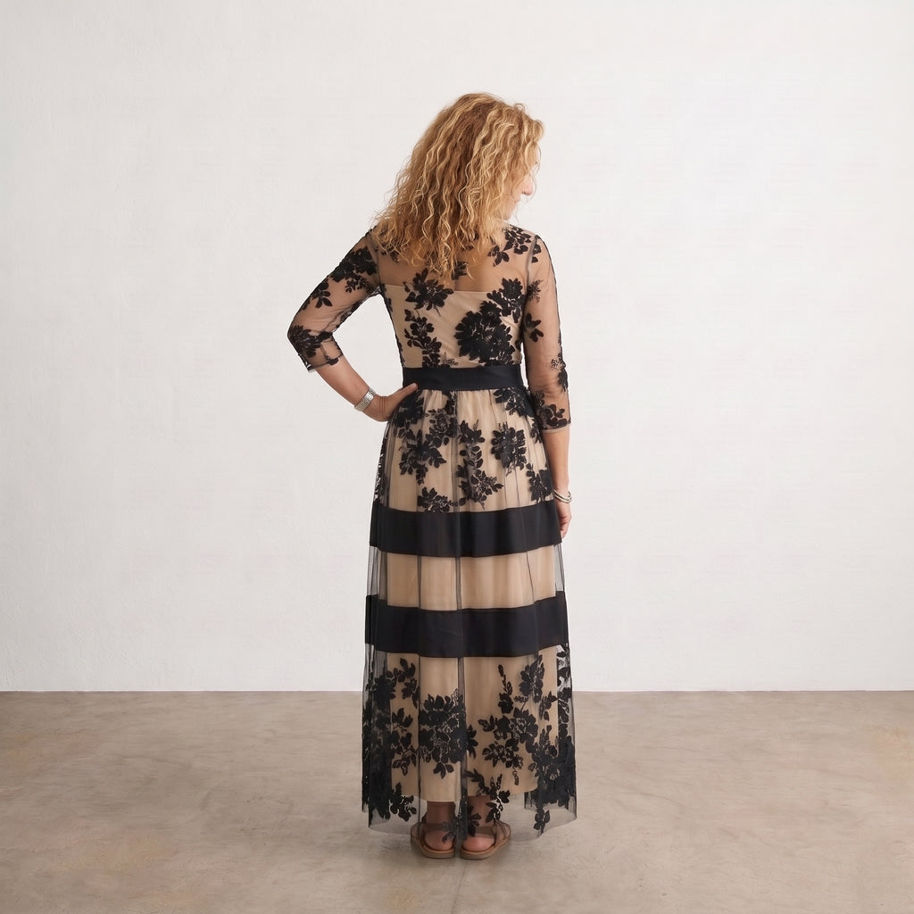 Vestido largo de tul negro con flores, franjas beige y azul marino, vista trasera.