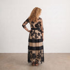Vestido largo de tul negro con flores, franjas beige y azul marino, vista trasera.