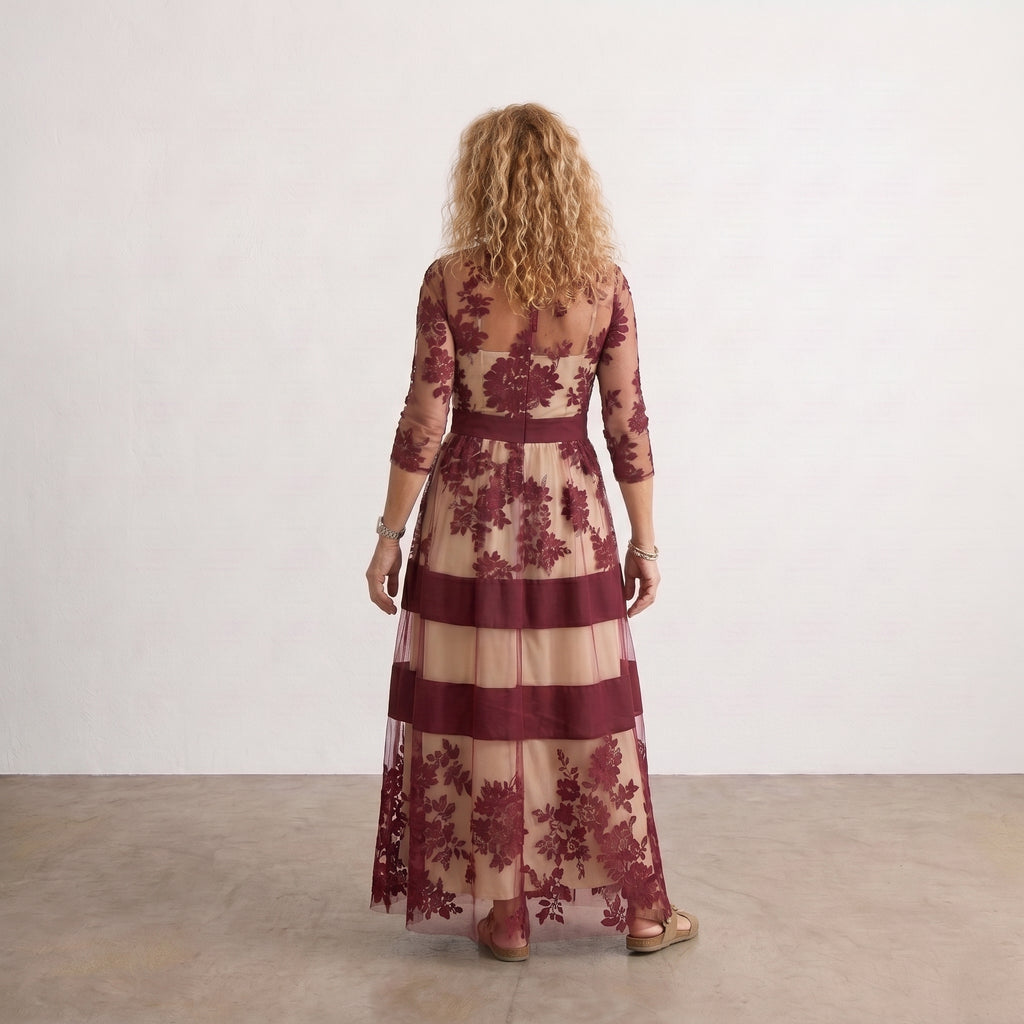 Vestido largo de tul granate con flores bordadas y franjas beige, mangas tres cuartos.