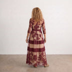 Vestido largo de tul granate con flores bordadas y franjas beige, mangas tres cuartos.