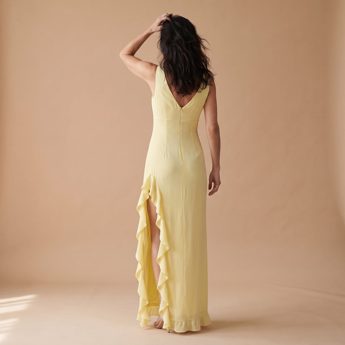 Vestido largo sin mangas amarillo claro, escote en V y volantes en un lateral