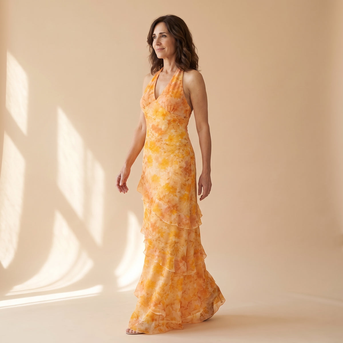 Vestido largo naranja con estampado floral, escote en V y falda por capas