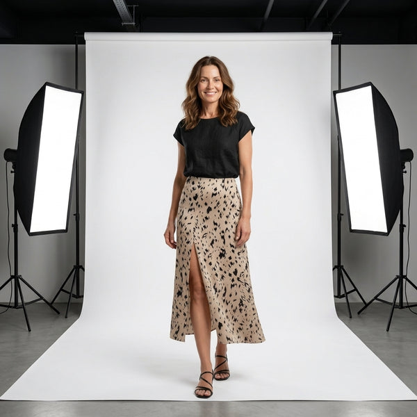 Falda midi animal print beige con manchas negras, en modelo de frente