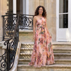 Vestido largo estampado asimétrico de una manga, cintura fruncida, fondo rosa con flores.