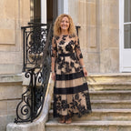 Vestido largo de tul negro con flores, franjas beige y azul marino, mangas tres cuartos.