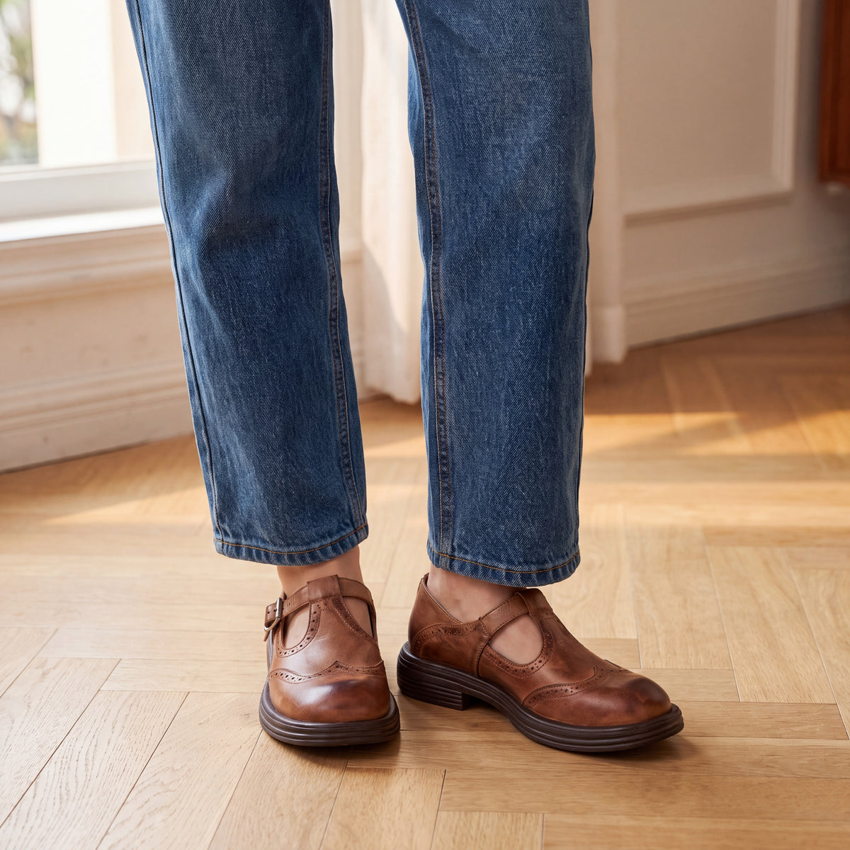 Mocasín Louisa™ de cuero marrón con hebilla, puesto con jeans