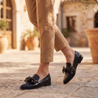 Mocasines negros tipo loafer con lazo frontal, con pantalón beige