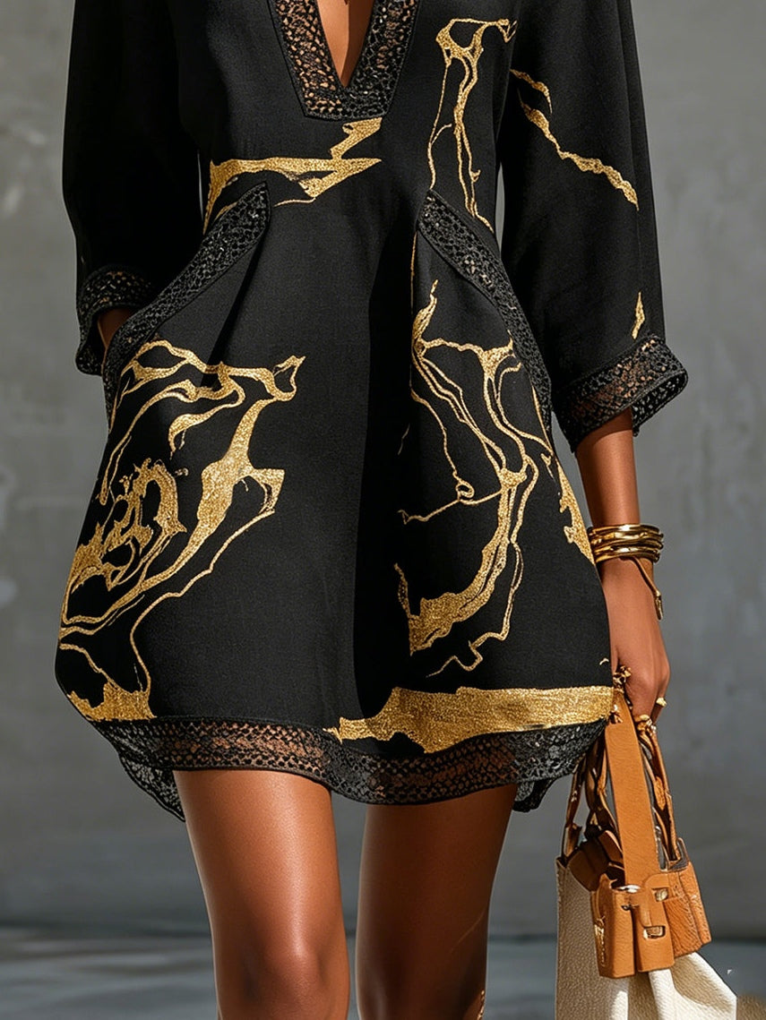 Minivestido negro con estampado dorado, dobladillo con borde oscuro y manga 3/4