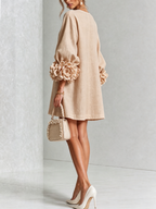 Vestido corto beige con botones florales y mangas con flores 3D en los puños.