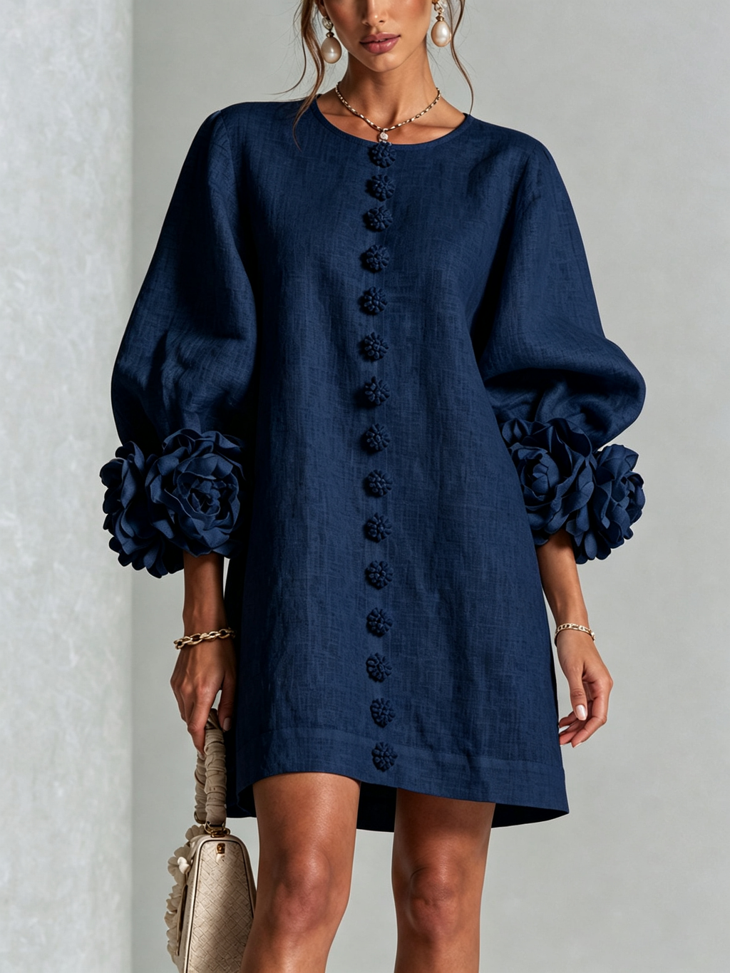 Minivestido azul marino con botones al frente y mangas con flores voluminosas.