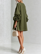 Vestido de lino verde oliva con botones florales y mangas con flores voluminosas, vista trasera