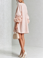 Vestido corto de lino color rosa claro con botones florales y mangas con flores 3D.