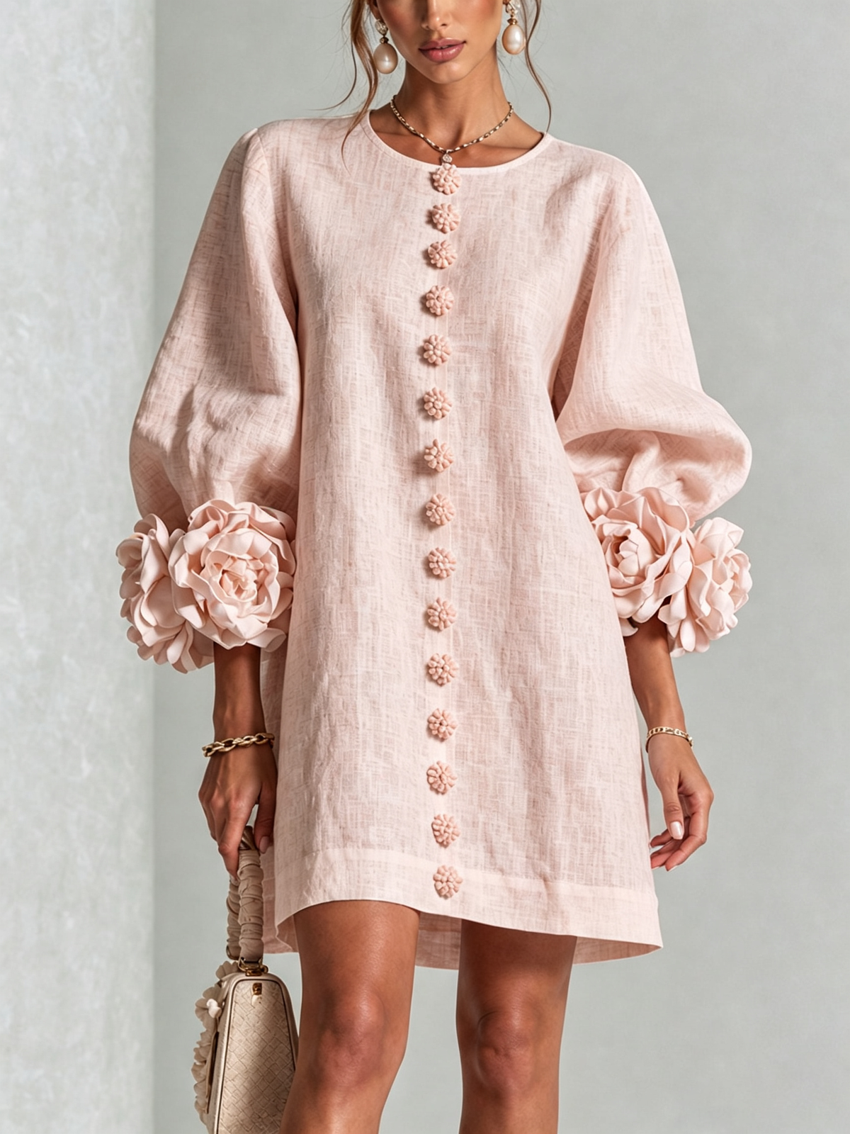 Minivestido rosa con botones al centro y mangas con flores tipo capullo.