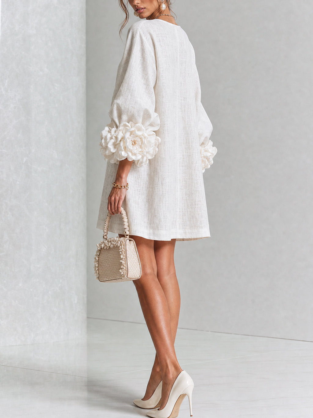 Vestido blanco de lino con botones florales y mangas con flores voluminosas, vista trasera